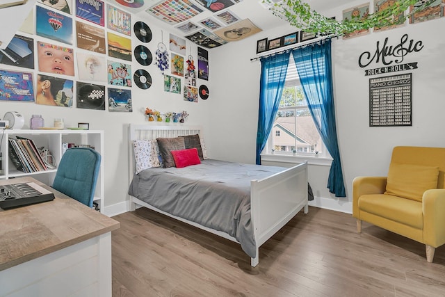 bedroom featuring baseboards and wood finished floors