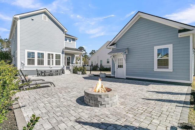 rear view of property with a patio area, fence, and an outdoor fire pit