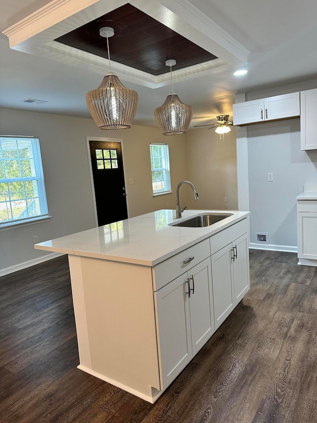 kitchen with dark wood-type flooring, pendant lighting, white cabinets, and sink