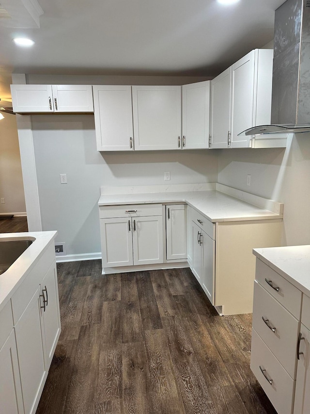 kitchen featuring wall chimney range hood, white cabinets, dark hardwood / wood-style flooring, and sink