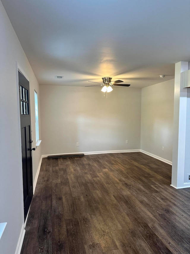 spare room featuring dark wood-type flooring and ceiling fan