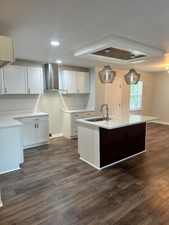 kitchen featuring sink, decorative light fixtures, wall chimney exhaust hood, white cabinetry, and dark hardwood / wood-style flooring