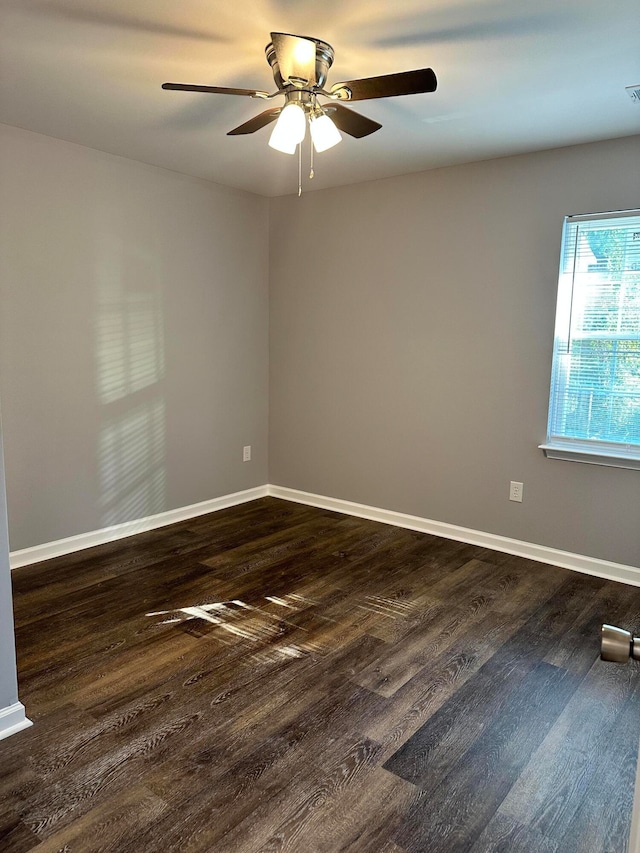 empty room with dark wood-type flooring and ceiling fan