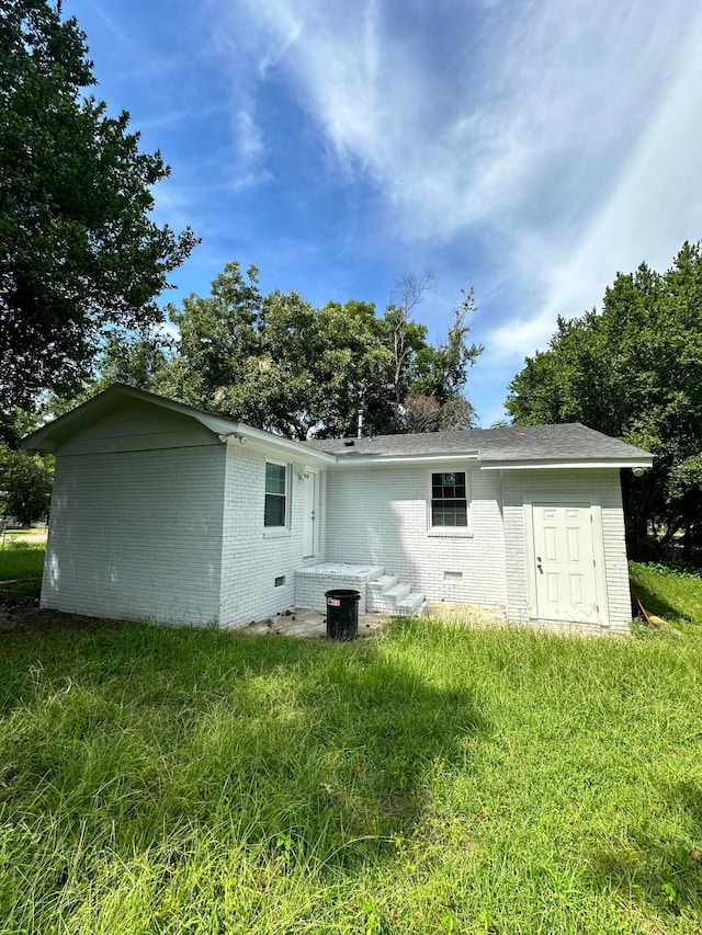 back of property featuring a lawn