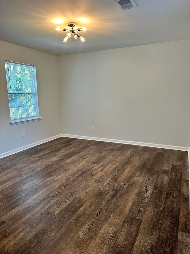 unfurnished room with dark wood-type flooring