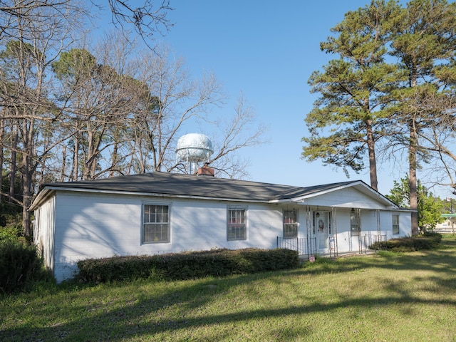 view of front of property featuring a chimney and a front lawn