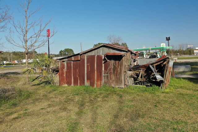 view of pole building with fence and a yard