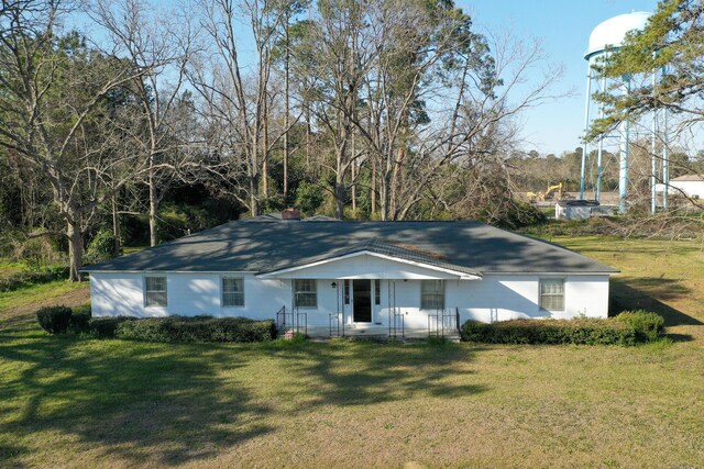 ranch-style home with a front yard and a chimney