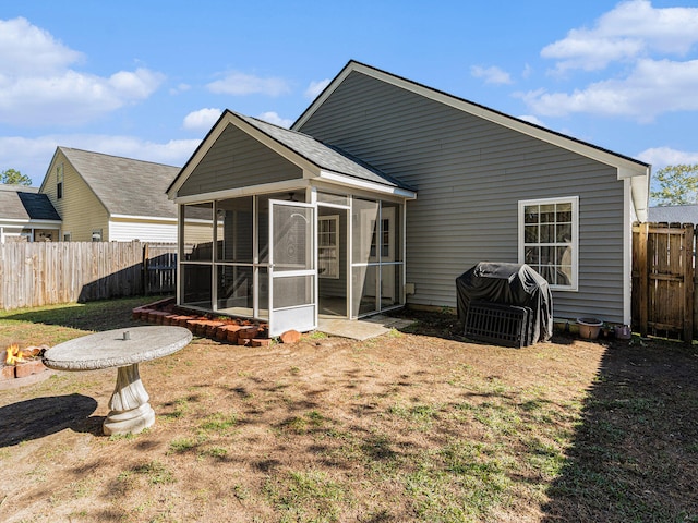 rear view of house with a sunroom and a yard