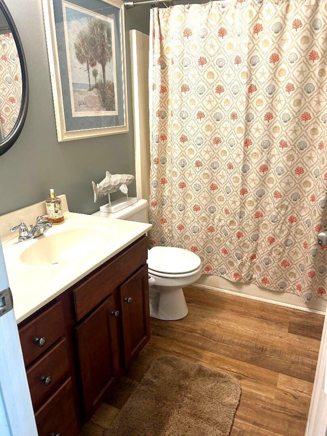 bathroom featuring wood-type flooring, vanity, and toilet