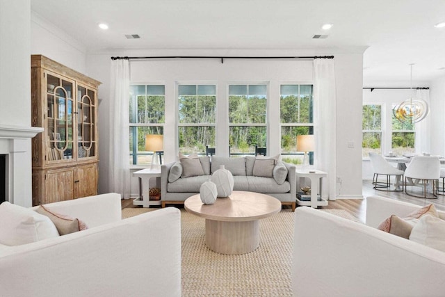 living room with a fireplace, visible vents, wood finished floors, and recessed lighting