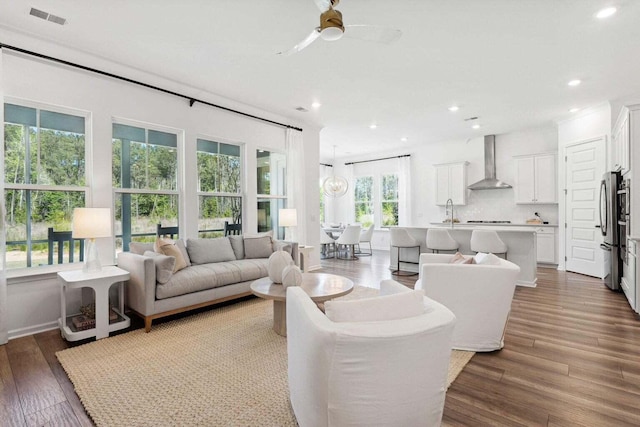 living area with ceiling fan, visible vents, wood finished floors, and recessed lighting