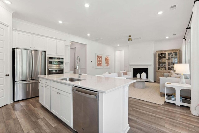 kitchen featuring dark wood-style floors, appliances with stainless steel finishes, a fireplace, and a sink