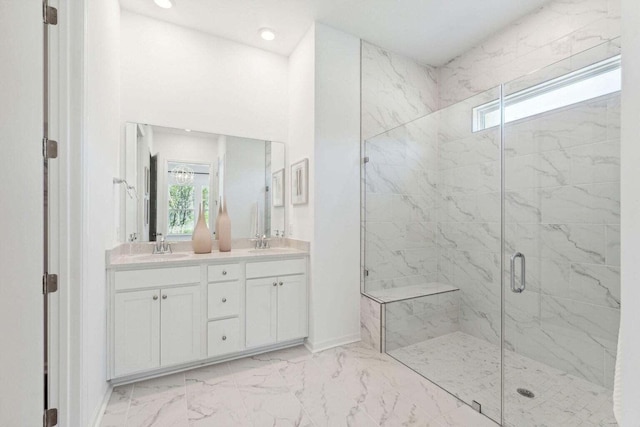 bathroom with double vanity, marble finish floor, a marble finish shower, and a sink