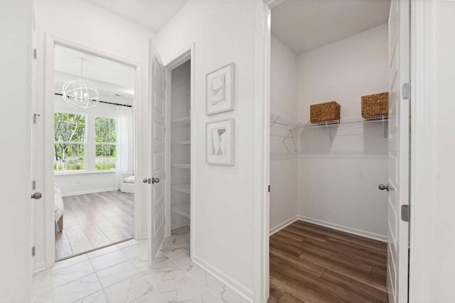 interior space with marble finish floor and an inviting chandelier