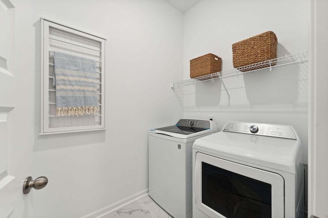 laundry room featuring laundry area, marble finish floor, baseboards, and separate washer and dryer