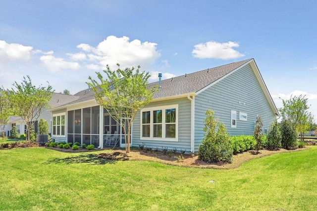 rear view of property with a sunroom and a yard