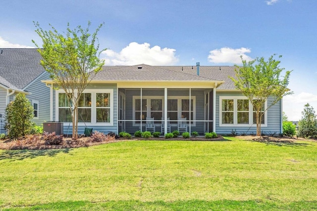 back of house with central AC unit, a lawn, and a sunroom