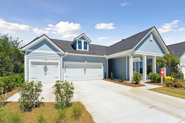 view of front facade featuring a garage, driveway, a shingled roof, and board and batten siding