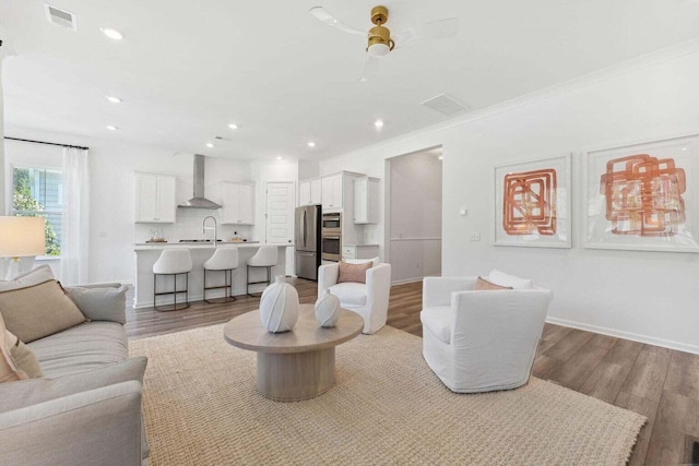 living area with light wood finished floors, visible vents, and baseboards