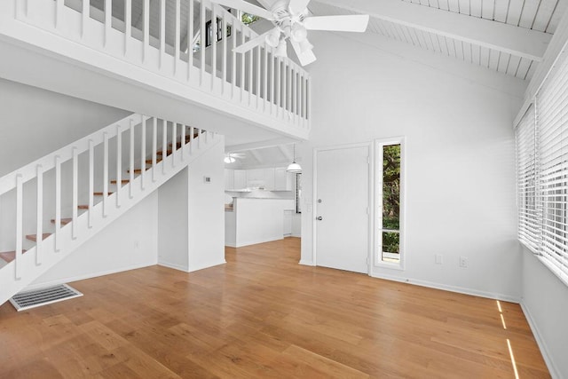 811 Treeloft Trce, Seabrook Island, SC 29455 - unfurnished living room with a ceiling fan, high vaulted ceiling, wood finished floors, beam ceiling, and stairs