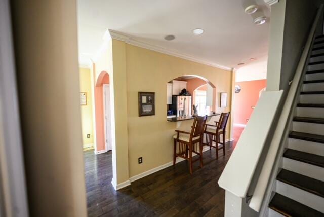 stairs featuring ornamental molding and hardwood / wood-style floors