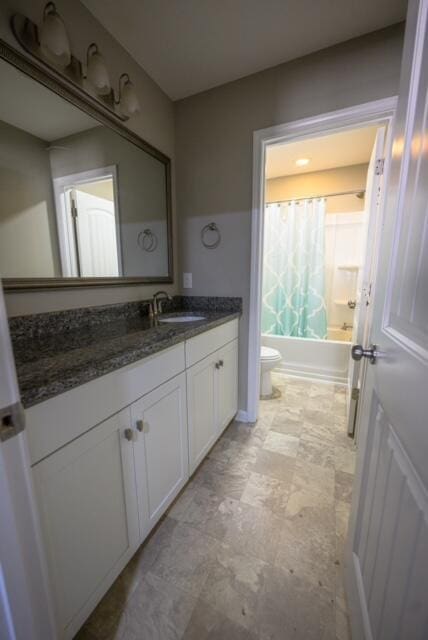 full bathroom with toilet, shower / bathtub combination with curtain, and vanity