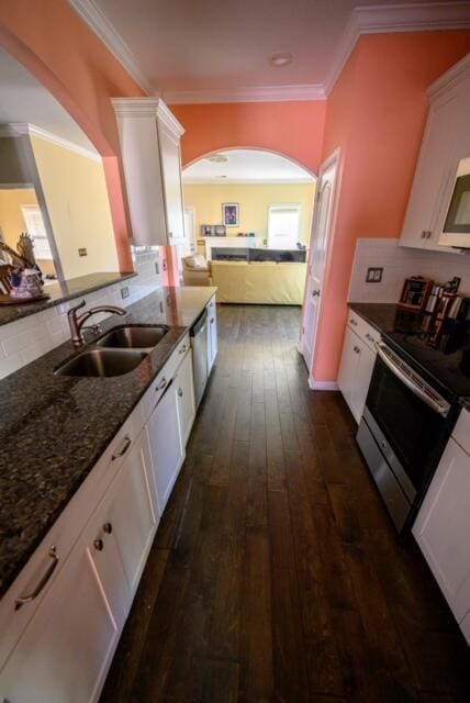 kitchen featuring sink, dark wood-type flooring, appliances with stainless steel finishes, white cabinets, and dark stone counters