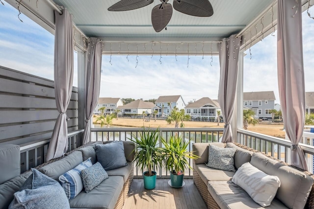 sunroom / solarium with ceiling fan and a residential view