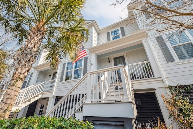 view of front of house with stairway, covered porch, and an attached garage