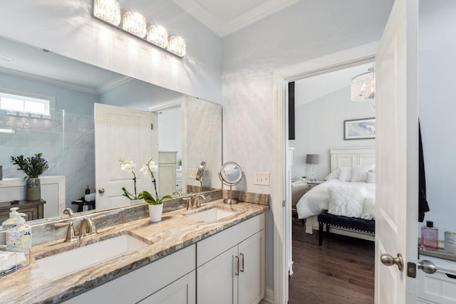 bathroom with double vanity, crown molding, a sink, and wood finished floors