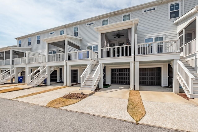 view of front of property with a sunroom, ceiling fan, stairway, and concrete driveway