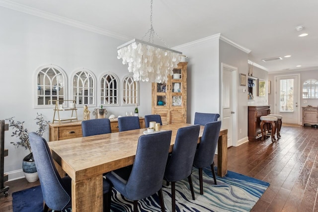 dining space featuring dark wood-style flooring, recessed lighting, an inviting chandelier, ornamental molding, and baseboards