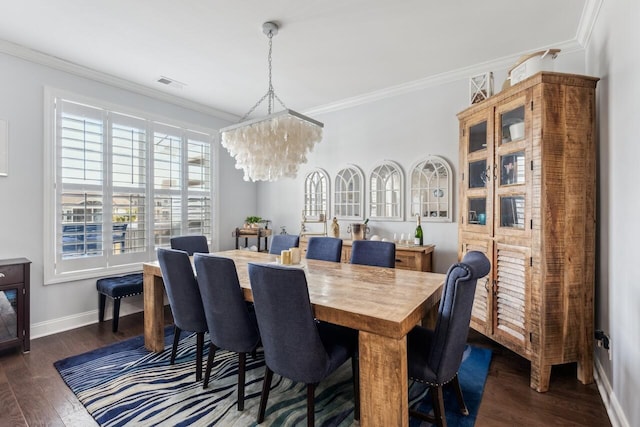 dining room with baseboards, visible vents, dark wood finished floors, and crown molding