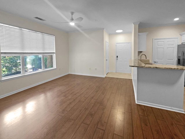 unfurnished living room with ceiling fan and wood-type flooring