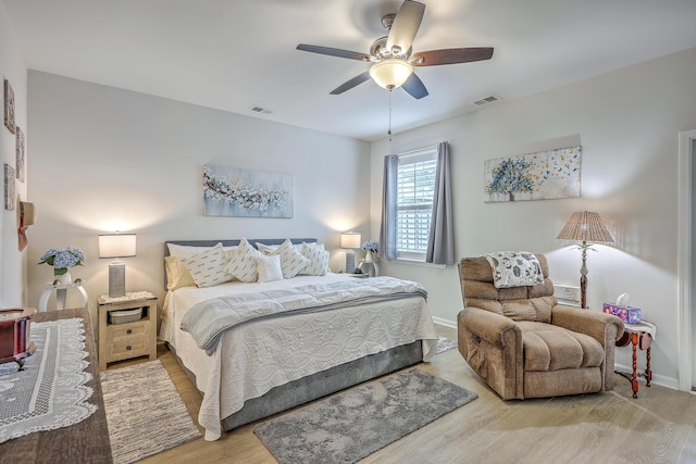 bedroom with visible vents, baseboards, light wood finished floors, and ceiling fan