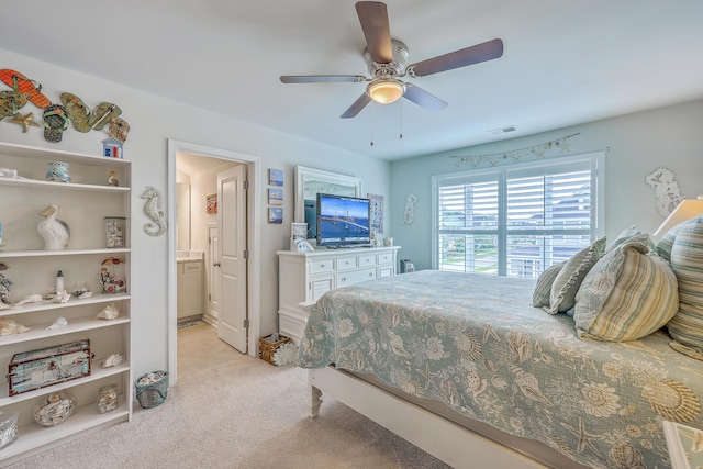 bedroom featuring light colored carpet, a ceiling fan, visible vents, and connected bathroom