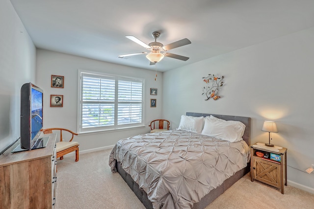 bedroom with baseboards, a ceiling fan, and light carpet