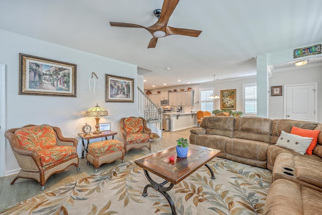 living room featuring light wood-type flooring, ceiling fan, stairway, and recessed lighting