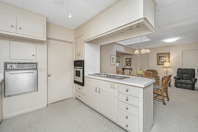 kitchen with kitchen peninsula, appliances with stainless steel finishes, and light colored carpet