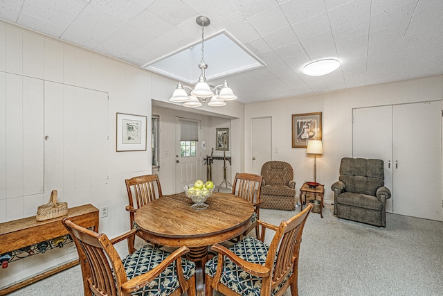 dining space with carpet flooring and an inviting chandelier