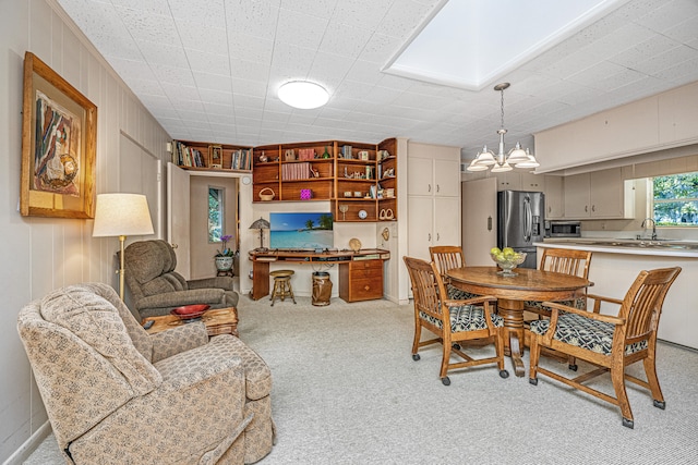 dining space featuring light colored carpet, sink, and wooden walls