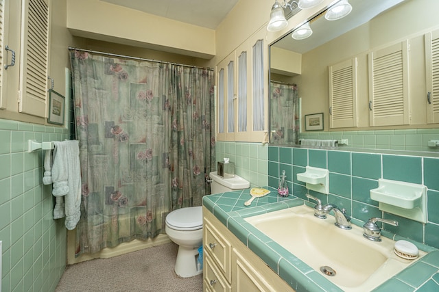 bathroom featuring vanity, tile walls, and toilet