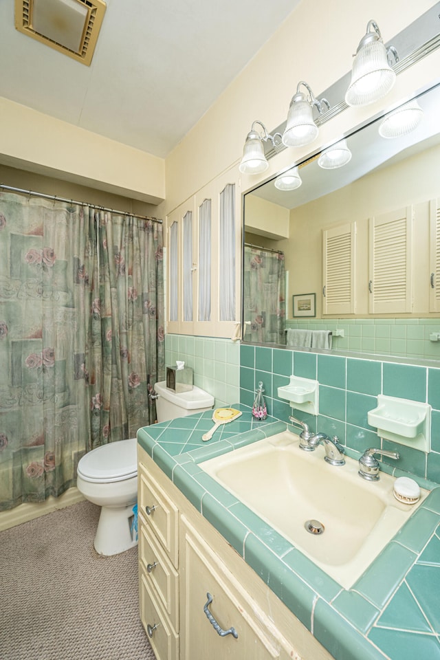 bathroom with tasteful backsplash, vanity, and toilet