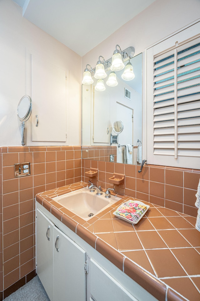 bathroom with tile patterned floors, vanity, and tile walls