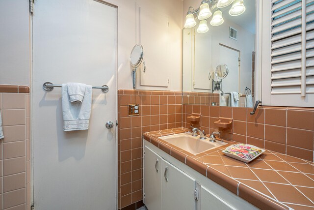 bathroom featuring tasteful backsplash, vanity, and tile walls