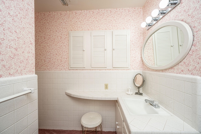 bathroom with vanity and tile walls