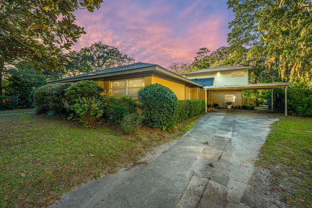 view of front of house with a lawn and a carport