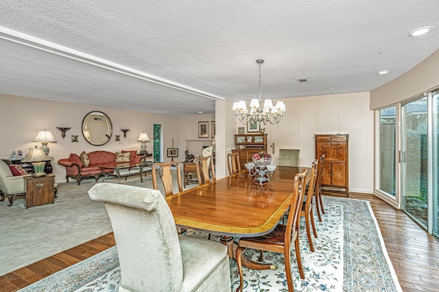 dining room with hardwood / wood-style floors, a chandelier, and a textured ceiling