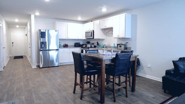 dining space featuring baseboards, dark wood-style floors, and recessed lighting